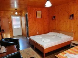 a bedroom with a bed in a room with wooden walls at Pensiunea Solinia in Dunavăţu de Jos +41 photos