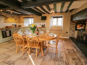 a kitchen with a wooden table and chairs at Little Bicton in Craven Arms