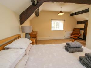 a bedroom with a large white bed and a chair at Little Bicton in Craven Arms