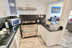 a kitchen with white cabinets and a microwave at Luxury Sea View Beachfront 3 Bedroom Apt, JBR in Dubai