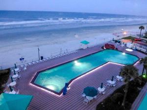 a large swimming pool next to the beach at Amazing Ocean View Studio Daytona Beach in Daytona Beach
