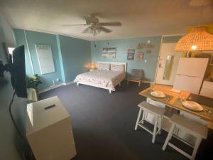 Amazing Ocean View Studio Daytona Beach في دايتونا بيتش: غرفة نوم بسرير وطاولة وطاولة طعام