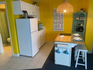 a kitchen with a white refrigerator and a table at Amazing Ocean View Studio Daytona Beach in Daytona Beach