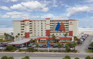 a large hotel with a parking lot next to the ocean at Amazing Ocean View Studio Daytona Beach in Daytona Beach