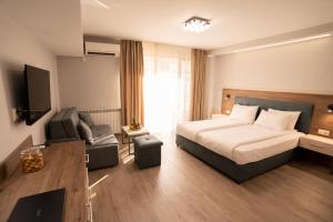 ein Hotelzimmer mit einem Bett und einem Sofa in der Unterkunft Guest House Velik in Sandanski