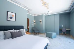 een slaapkamer met een wit bed en blauwe muren bij villa lion in Agioi Theodoroi