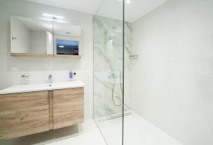 a bathroom with a sink and a glass shower at villa lion in Agioi Theodoroi +11 photos