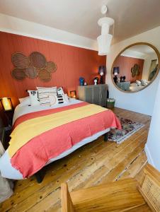 - une chambre avec un grand lit et un mur rouge dans l'établissement Saint Malo - Jolie Maison avec Jacuzzi 150m gare, à Saint-Malo