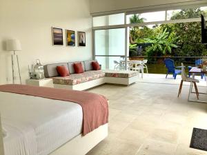 a bedroom with a bed and a couch and a patio at La Masia Hotel Boutique in Anapoima