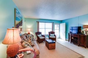 a living room with a couch and chairs and a tv at Destin Townhome with Balcony - Walk to the Beach! in Destin