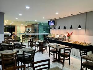 un restaurante con mesas, sillas y una barra en Destak Hotel Residence, en Palmares