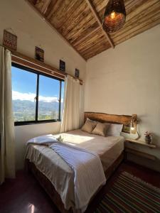 a bedroom with a bed and a large window at La Casita de Charo 1 in Constanza