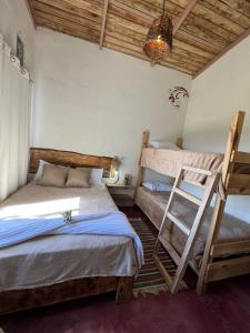 a bedroom with two bunk beds and a ladder at La Casita de Charo 1 in Constanza