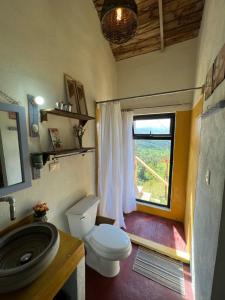 a bathroom with a toilet and a window at La Casita de Charo 1 in Constanza