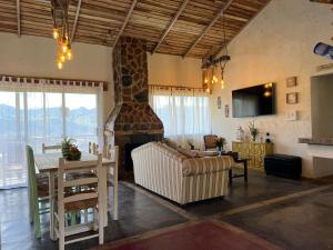 a living room with a living room with a fireplace at La Casita de Charo 1, disfruta de tiempo memorable en la montaña in Constanza