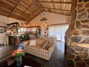 a living room with a couch and a kitchen at La Casita de Charo 1, disfruta de tiempo memorable en la montaña in Constanza