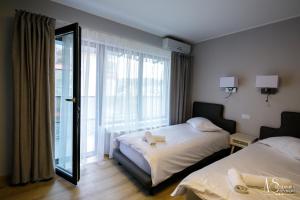 a hotel room with two beds and a mirror at Pensiunea AS in Floreşti