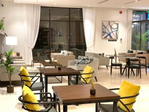هوتيلتن قرطبه HOTELTEN Qurtubah في الرياض: مطعم به طاولات وكراسي به وسائد صفراء
