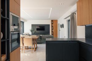 a kitchen with a black counter top and a living room at Black Caviar in Asprouliánoi