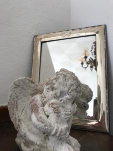 une statue d'un ange devant un miroir dans l'établissement B.E.A. Maison, à La Spezia