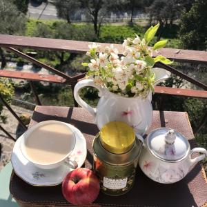 un jarrón con flores y manzanas sobre una mesa en B.E.A. Maison, en La Spezia