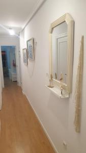 a hallway with a mirror on a white wall at Ático Berni in Santa Pola +18 photos