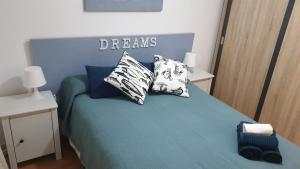 - une chambre avec un lit bleu et des oreillers dans l'établissement Ático Berni, à Santa Pola