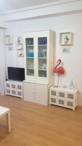 a living room with white cabinets and a red flamingo statue at Ático Berni in Santa Pola