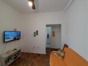 sala de estar con TV de pantalla plana en la pared en Glória' loft, en Río de Janeiro