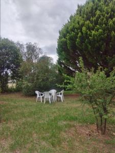 dos sillas blancas y una mesa en un campo en •JADE• Casas de alquiler en Los Molles