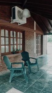 2 sillas verdes y una mesa en el patio en •JADE• Casas de alquiler en Los Molles