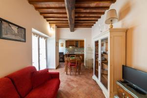 ein Wohnzimmer mit einem roten Sofa und einem Esszimmer in der Unterkunft Podere Vergianoni con piscina e vista mozzafiato in Tavarnelle in Val di Pesa
