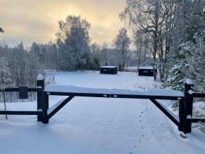 een bank bedekt met sneeuw in een tuin bij Ieviņi atpūtas vieta 