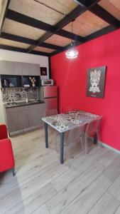una sala da pranzo con tavolo e parete rossa di GH Rooms Catania a Catania
