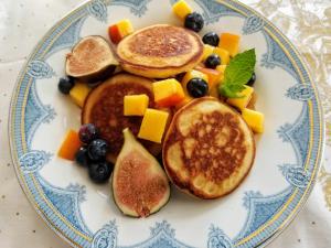 a plate of pancakes and fruit on a table at Buffalo Harmony House in Buffalo