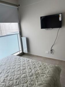 1 dormitorio con 1 cama y TV en la pared en Start San Martín 3 en Buenos Aires