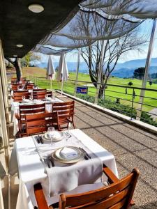 um restaurante com mesas e cadeiras com vista para um campo em Luxury Home - Vila Golfe Amarante em Amarante