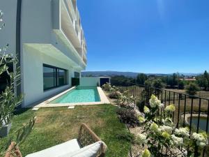 a backyard with a swimming pool and a house at Luxury Home - Vila Golfe Amarante in Amarante