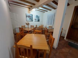 een eetkamer met houten tafels en stoelen bij ALBERGUE CASA LAS ANGELITAS 