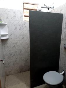 a bathroom with a toilet and a black door at RANCHO PÉ DA SERRA in Capitólio