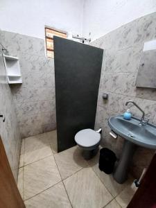 a bathroom with a toilet and a sink at RANCHO PÉ DA SERRA in Capitólio