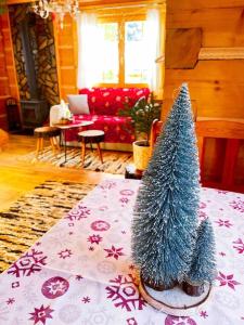 a christmas tree on a table in a living room at Uroczy domek w Rabce-Zdrój in Zaryte