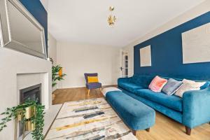 - un salon avec un canapé bleu et une cheminée dans l'établissement Spacious 3 bed house in North Leeds perfect for families & longer stays, à Adel