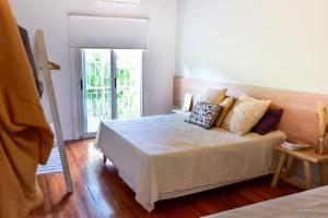 um quarto com uma cama com almofadas em Casa Caravan - Plant Based Concept House em Buenos Aires