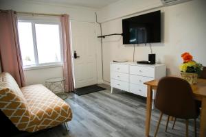 a living room with a tv and a couch and a table at Westview Centre Motel in Powell River