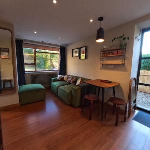 a living room with a green couch and a table at The Hideaway Apartment, Bath in Bath +19 photos