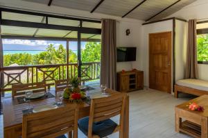 une salle à manger avec une table et un balcon dans l'établissement FARE ATEA, à Bora Bora