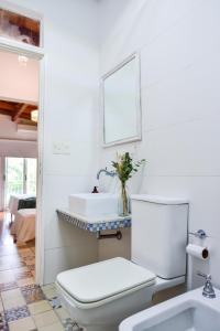a white bathroom with a toilet and a sink at Casa Caravan - Plant Based Concept House in Buenos Aires