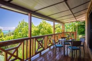 eine abgeschirmte Veranda mit einem Tisch und Stühlen in der Unterkunft FARE ATEA in Bora Bora