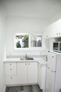 a white kitchen with a sink and a window at Westview Centre Motel in Powell River